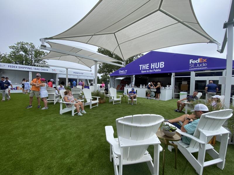 people sitting in chairs in the shady The Hub fan area
