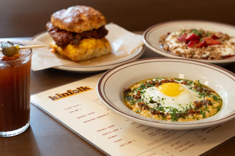 assortment of breakfast dishes: grits bowl, chicken biscuit sandwich over kinfolk menu