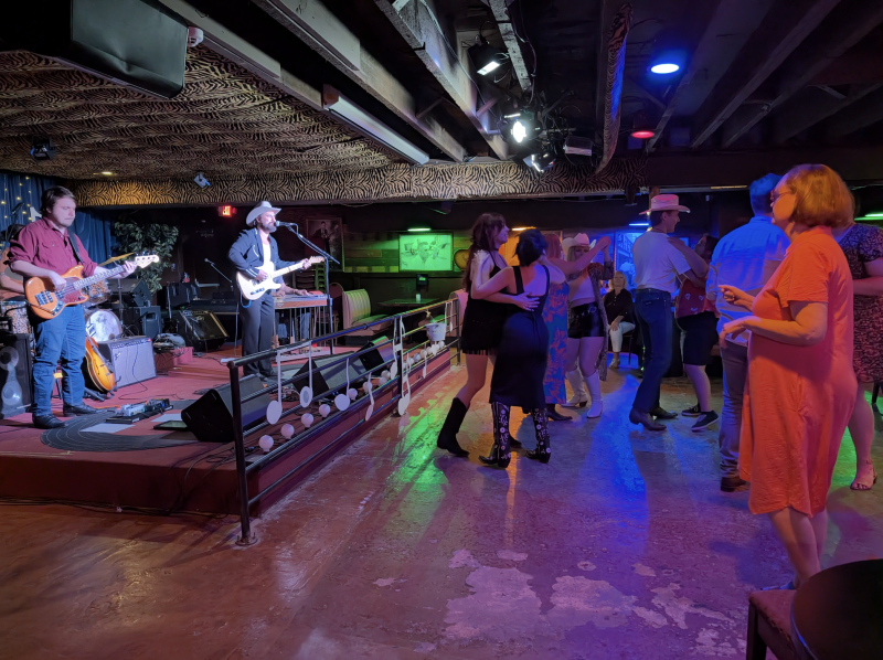 band plays on stage with people dancing