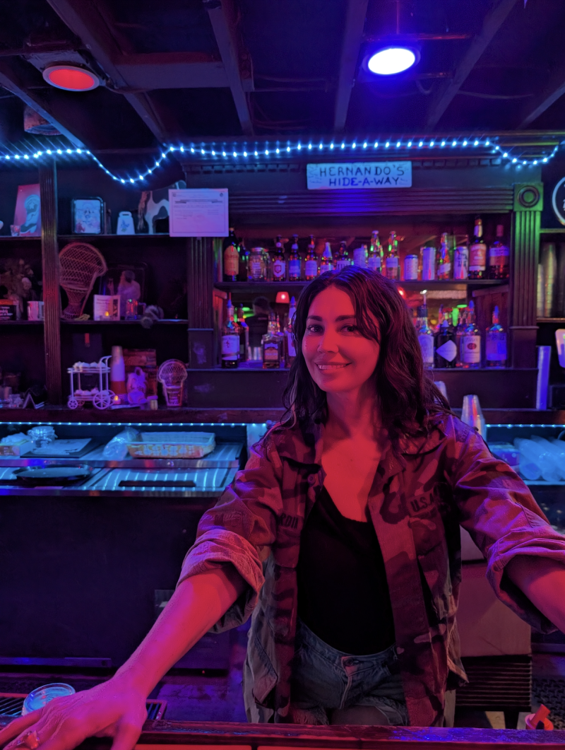 co-owner Celine smiles behind bar for photo