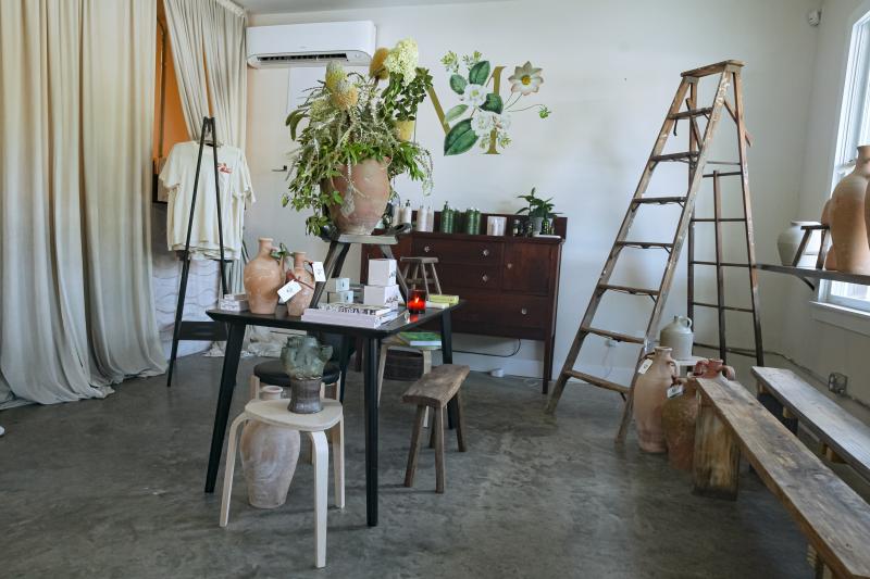 wide shot of shop with items on display, rustic ladder in corner