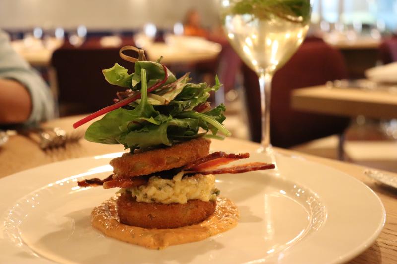 very tall sandwich with eggs, bacon, and lettuce