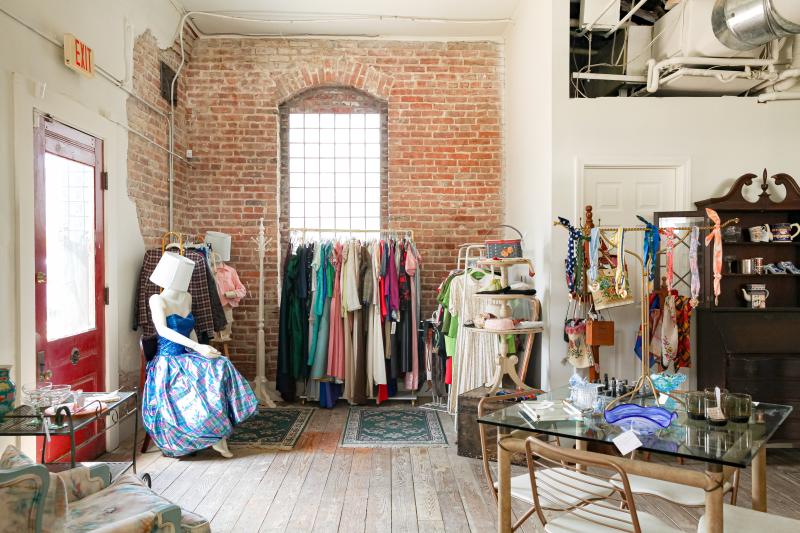 a room full of clothes with a maniquen placed in the middle