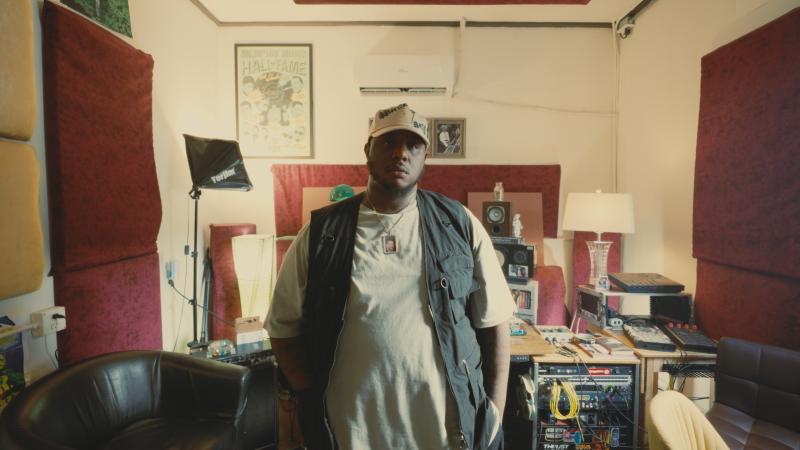 African American Man standing in front of recording equipment with his hands in pockets