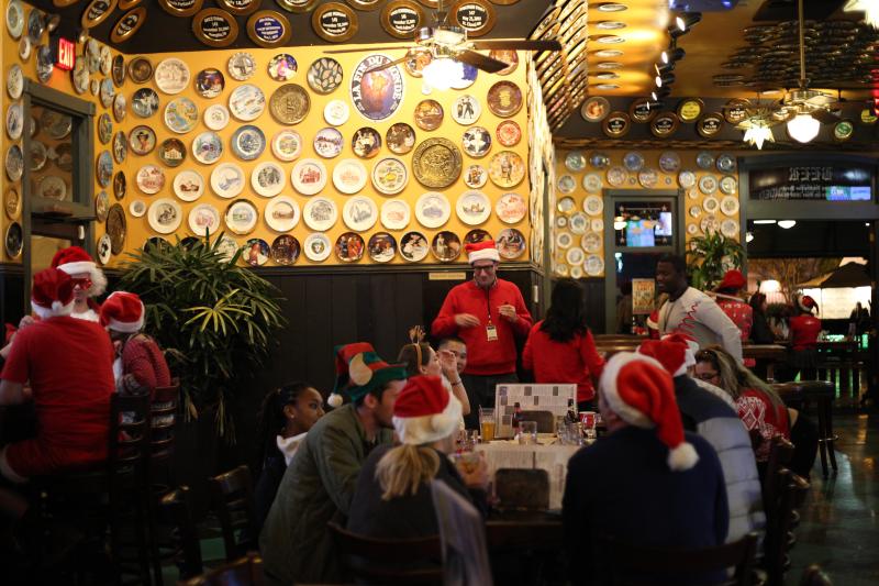 people dressed in Santa hats at bar