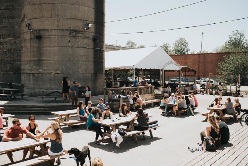 People sitting at the outdoor picnic tables at Wiseacre Brewing Co. on Broad Ave.