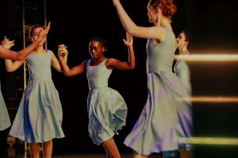 woman perform ballet on stage in blue dresses