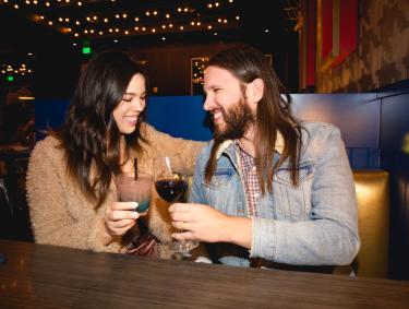 couple smiling and cheering a drink at dinner