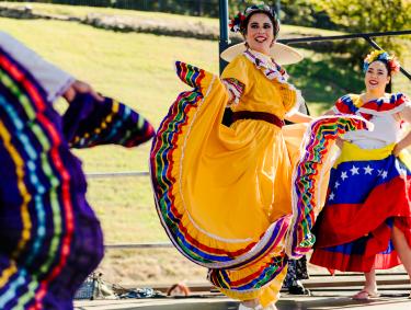 cazateatro dancers perform on stage in colorful cultural dresses