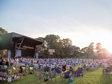 crowd of people on grassy lawn at Botanic Garden with music stage