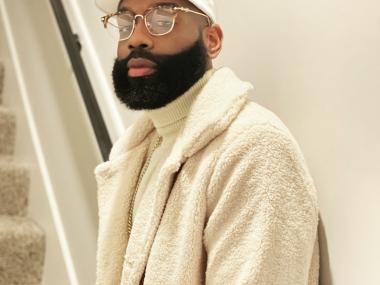 musician dress in a white coat and white hat with a beard