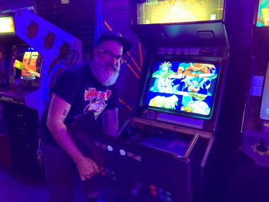 man fixing a video game at an arcade