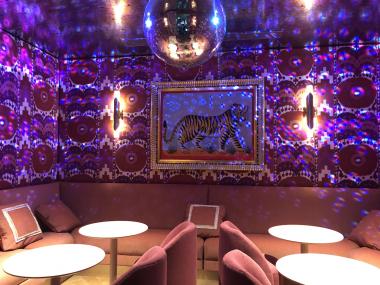 pink lit lounge room with disco ball and seating