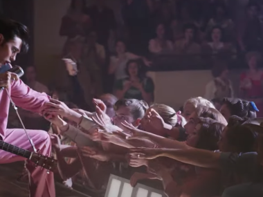 elvis reaching down to touch hands of crowd