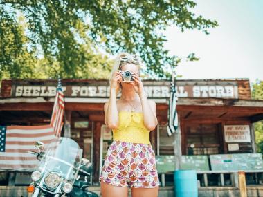 Girl snapping a photo in front of Shelby Forest General Store in Millington near Memphis | Oui We Girl