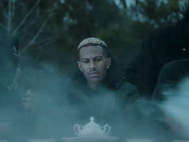 screen shot of music video man at table in the fog