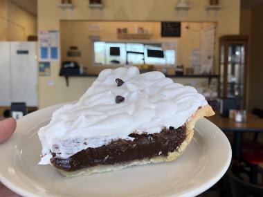 chocolate pie with whipped cream on top in a homey pie shop