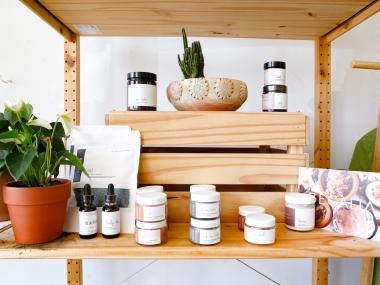 wooden shelf with body products in jars and a plant
