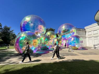 people walking on plaza with plastic bubbles