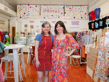 Two women standing in brightly lit shop