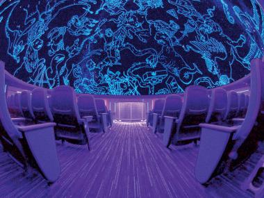 Wide shot of planetarium at MoSH with empty seats and ceiling lit up