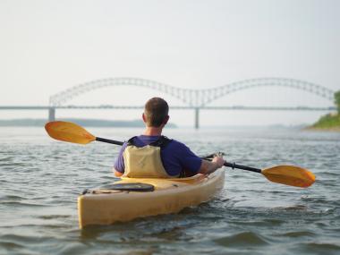person kayaking on river