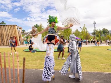 Tom Lee Park lady on stilts with colorful outfit on at the park