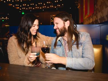 couple smiling and cheering a drink at dinner