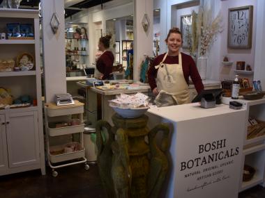 Boshi Botanicals owner poses at counter for photo