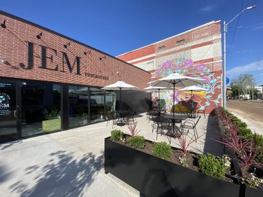 exterior of JEM Dining with patio and large art mural