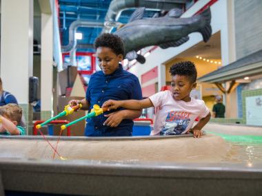 two young boys play with CMOM water exhibit