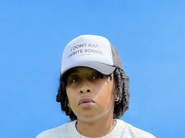 portrait of artist jus Bentley who wears a hat saying "I don't rap. I write songs."