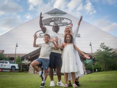 Family poses in front of Bass Pro Shops at the Pyramid.