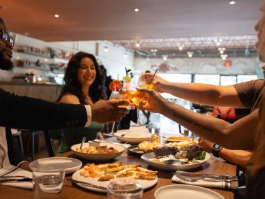 group of friends cheers drinks at dinner
