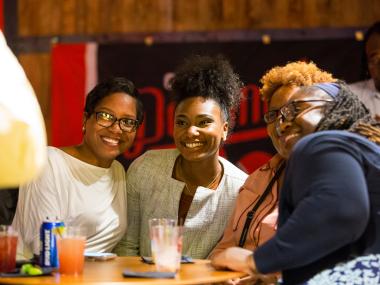 Three women smile for photo at Old Dominick