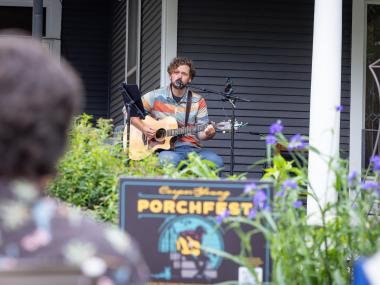 man plays guitar and sings during porchfest