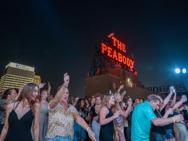 people dancing on peabody rooftop during rooftop party