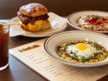assortment of breakfast dishes: grits bowl, chicken biscuit sandwich over kinfolk menu
