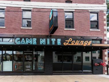 Game Nite Loung Building Exterior - Brick Building with Neon Sign Saying "Game Nite Loung" IN blue and Orange Lettering