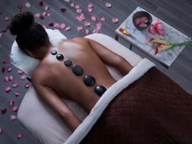 A person lays face down while getting a hot stone massage at Feathers Spa in Memphis