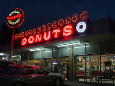Exterior of Gibson's Donuts with the red neon sign on above the entrance.